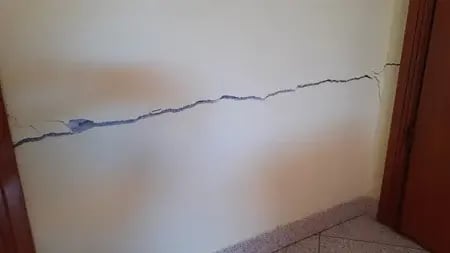 Fissura horizontal na parede que atravessa a parede de porta a porta